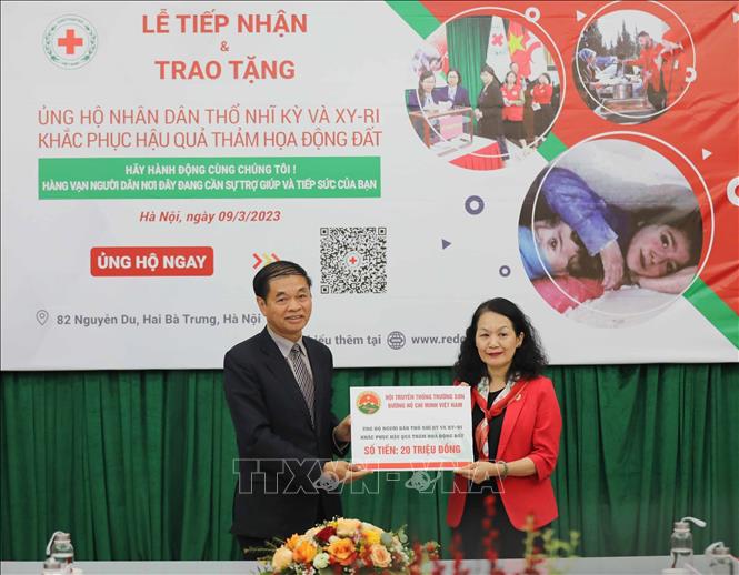 Chủ tịch Hội Chữ thập đỏ Việt Nam Bùi Thị Hòa tiếp nhận tượng trưng số tiền ủng hộ của Hội Truyền thống Trường Sơn - Hồ Chí Minh Việt Nam. Ảnh: Thanh Tùng - TTXVN 